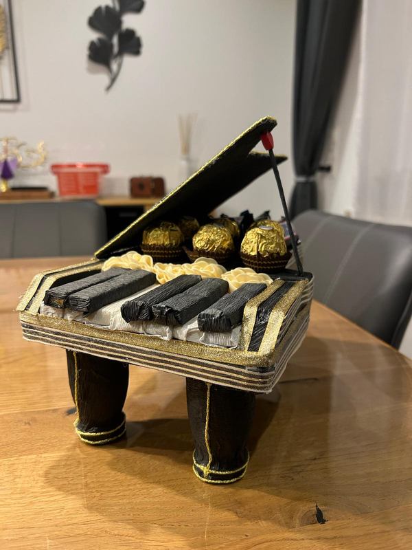 Nachgebauter Konzertflügel aus Krepppapier in Schwarz und Gold, gefüllt mit Ferrero Rocher