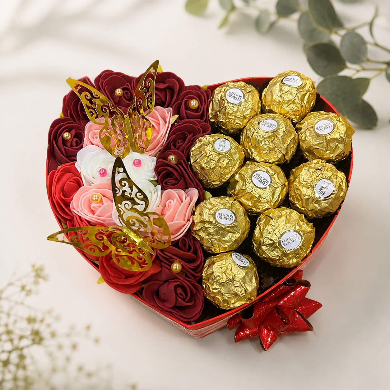 Herzförmige Geschenkbox mit Seifenrosen in Rot und Rosé, Ferrero Rocher und goldenen Schmetterlingen