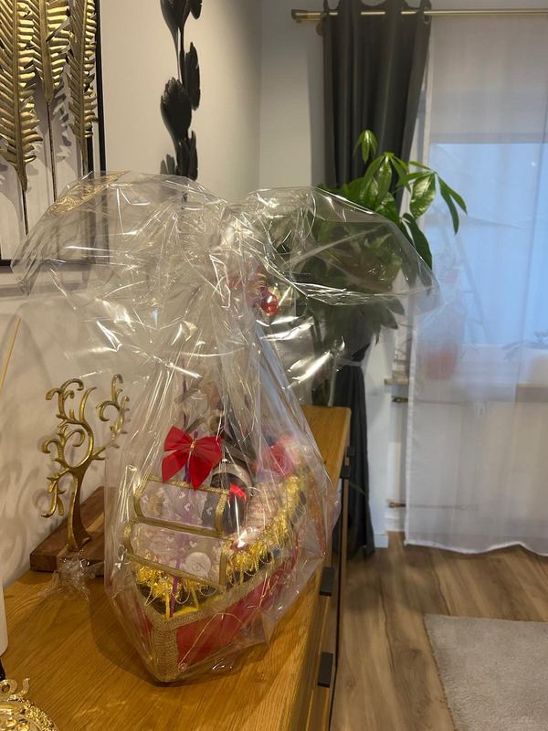 Geschenkschiff fertig verpackt in Klarsichtfolie mit roter Schleife